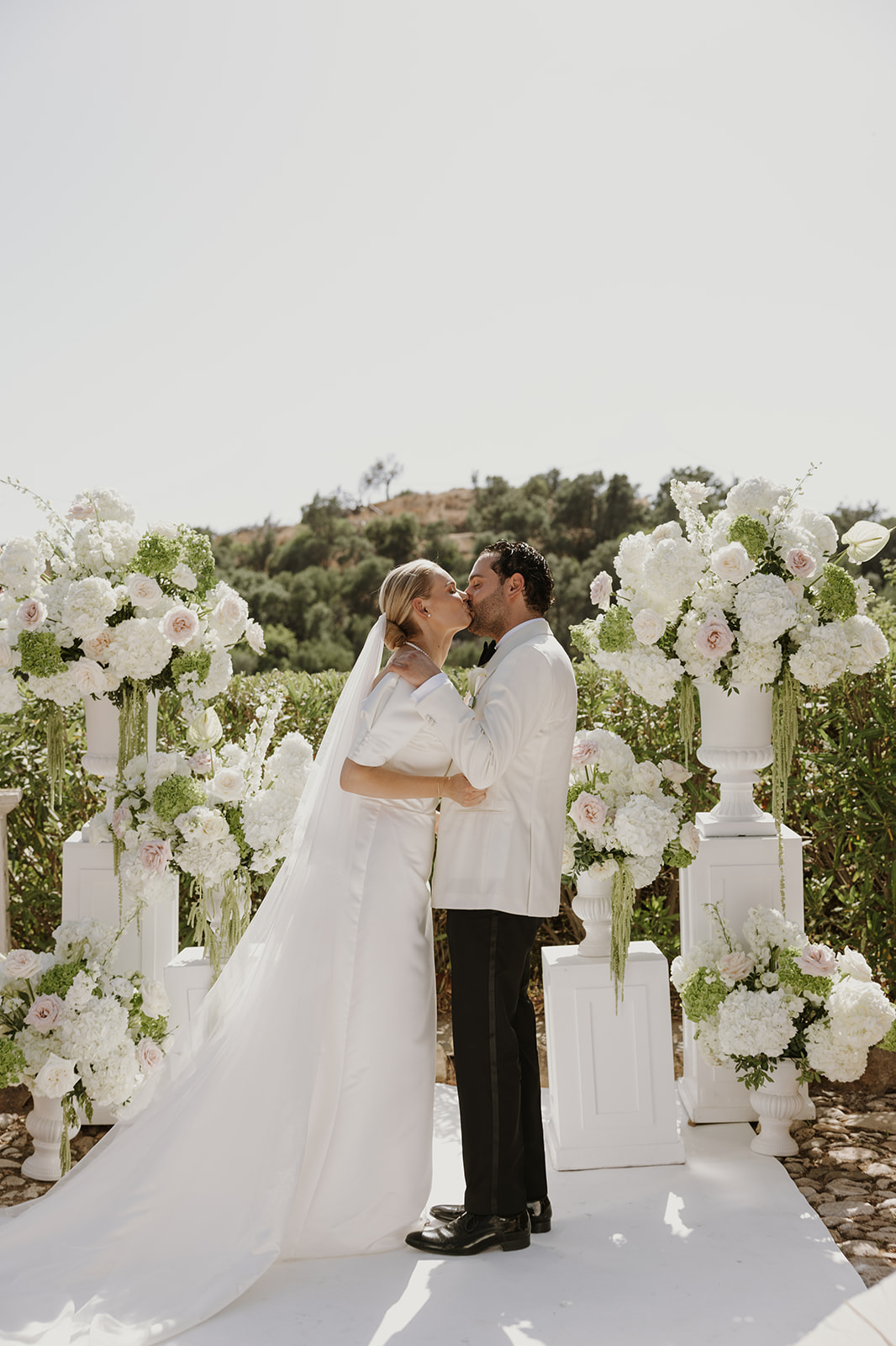 White pillars with floral arrangements for a wedding ceremony by Lemonface Deco, Marbella